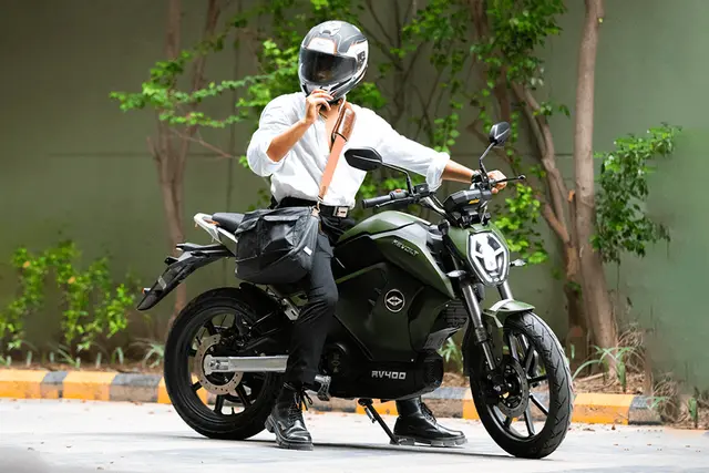 a rider wearing helmet and formal dress on silent revolt rv400 e bike
