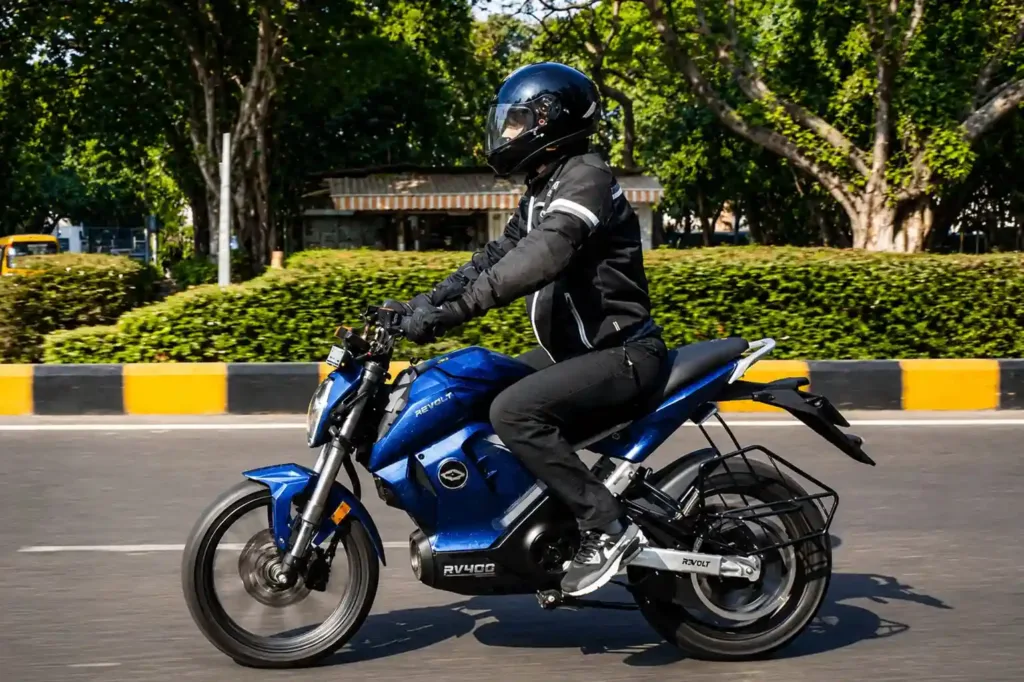 a rider wearing helmet going on road on bike revolt rv 400 top speed blue colour