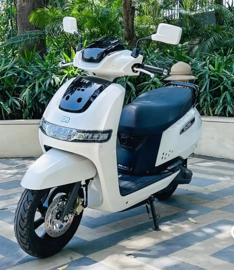 tvs iqube on road price white colour standing in front of garden